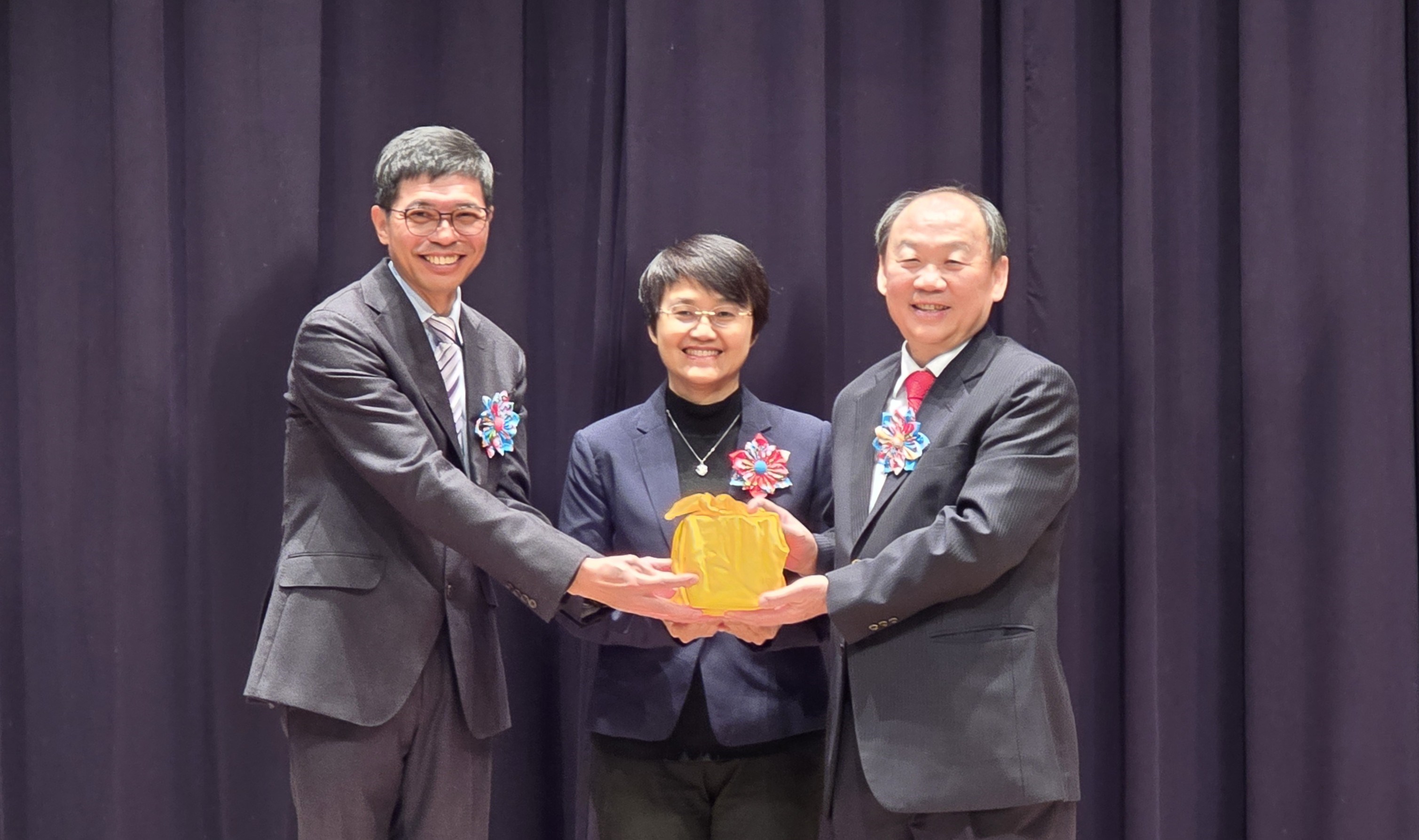 Hakka Affairs Council Minister Ku Hsiu-fei (middle) witnesses the passing over of leadership from former Director-General Ho Chin-liang (left) to new Director-General Hsieh Sheng-hsin (right)